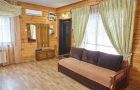 Гостиная зона дома на 12 человек с диваном и выходом к лестнице